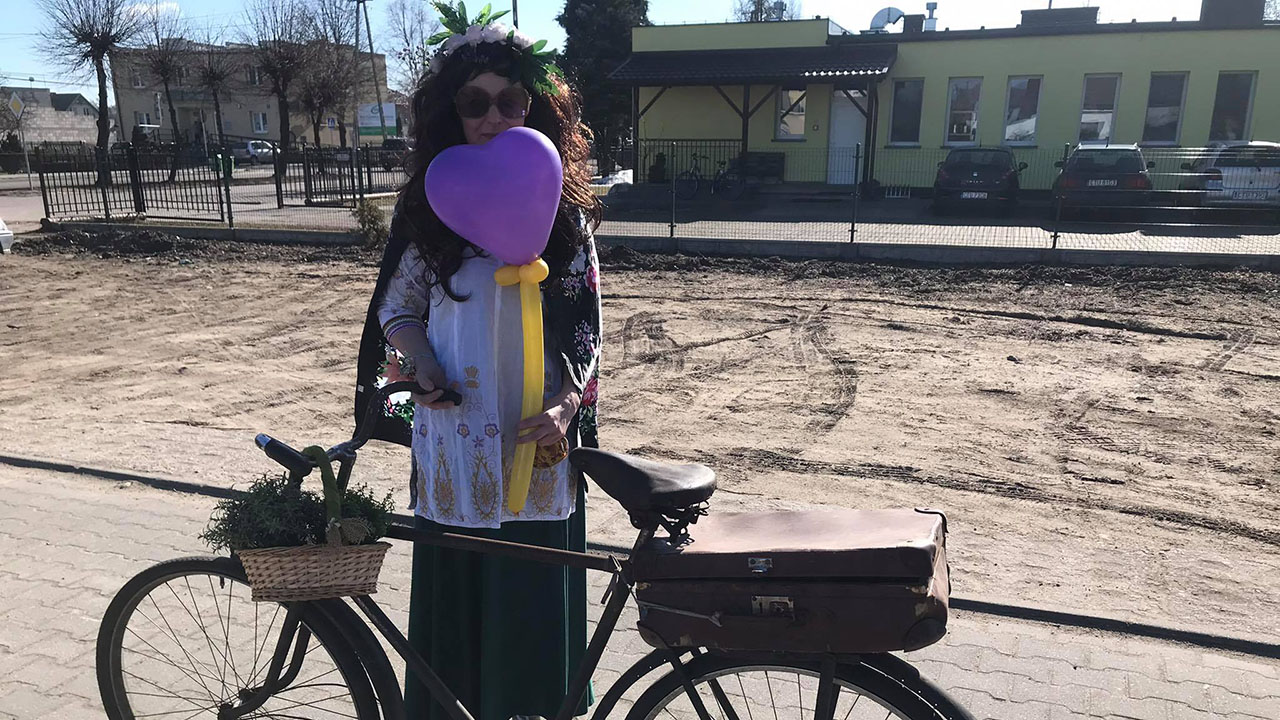 kobieta z rowerem na tle przedszkola