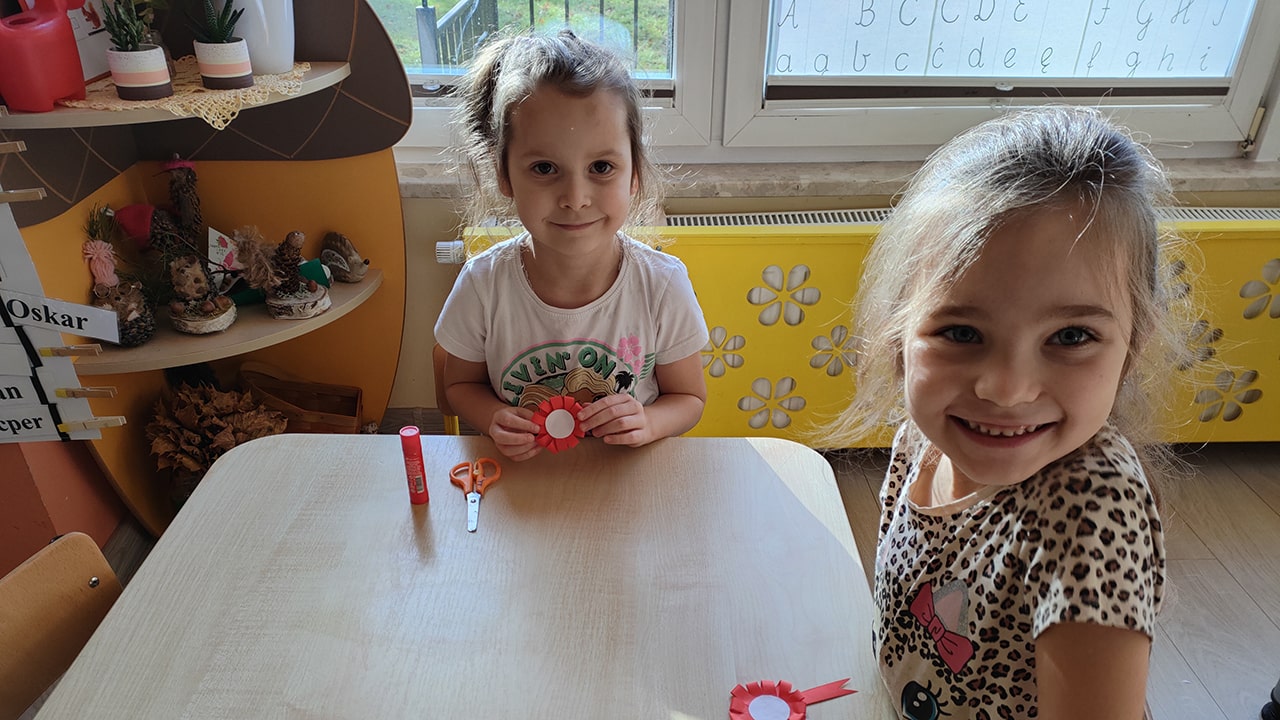 Dziewczynki pokazują własnoręcznie zrobione kokardy narodowe