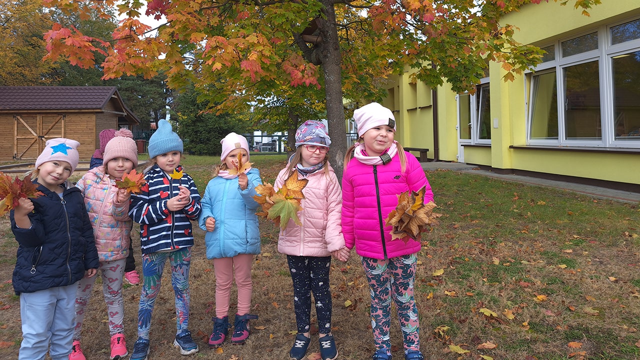 Grupa dziewczynek z swoimi bukietami z liści.