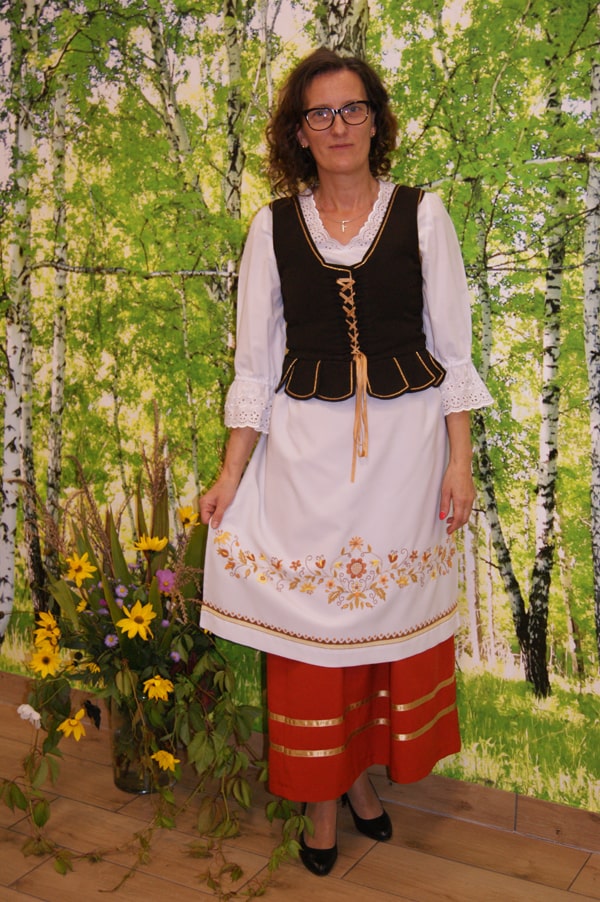 Anna Mania  w stroju borowiackim na tle brzóz